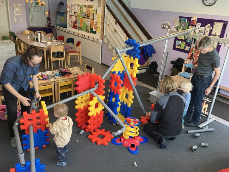 Väter mit ihren Kindern in Aktion beim Bau einer Kugelbahn.